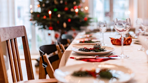 A neatly organized and festively decorated Christmas dinner table. Learn how to organize your home for the holidays in today’s blog.