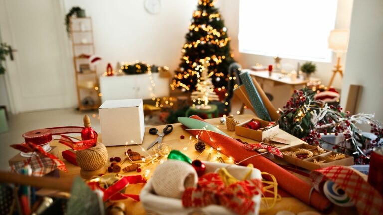 A living room is in disarray, with wrapping paper and decorations everywhere. Learn how to avoid holiday clutter.