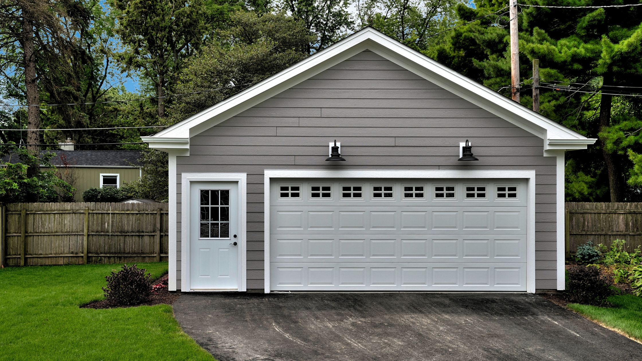 The exterior of a garage is pictured emphasizing the benefits of a tidy garage for summer.