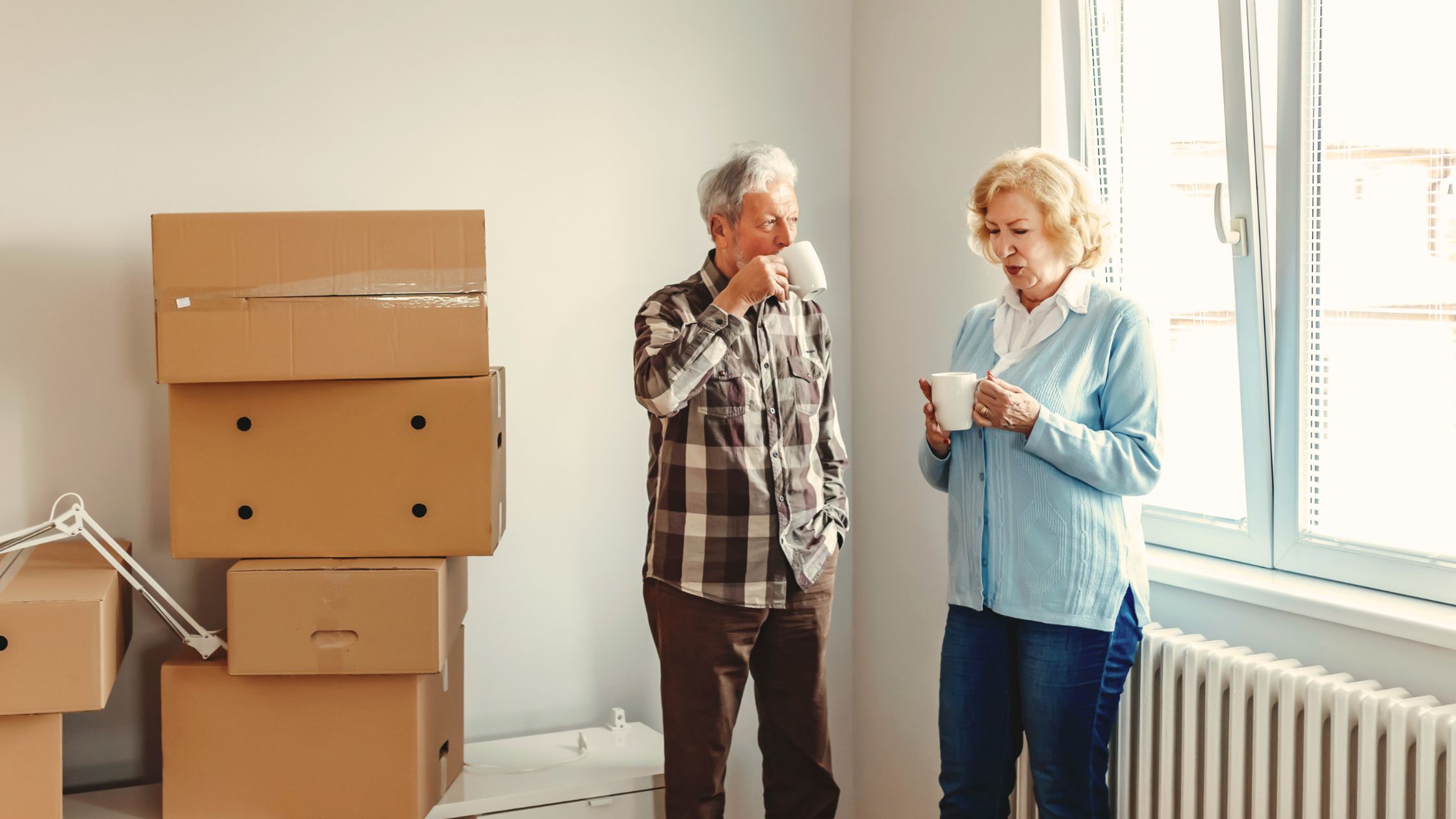 A retired couple enjoy a cup of coffee on moving day while preparing to downsize.
